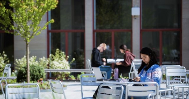 a few people sit at tables outside 